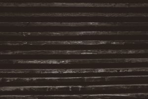 Estrutura de madeira com ripas horizontais escuras.