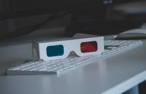 Óculos 3D sobre teclado de computador branco.